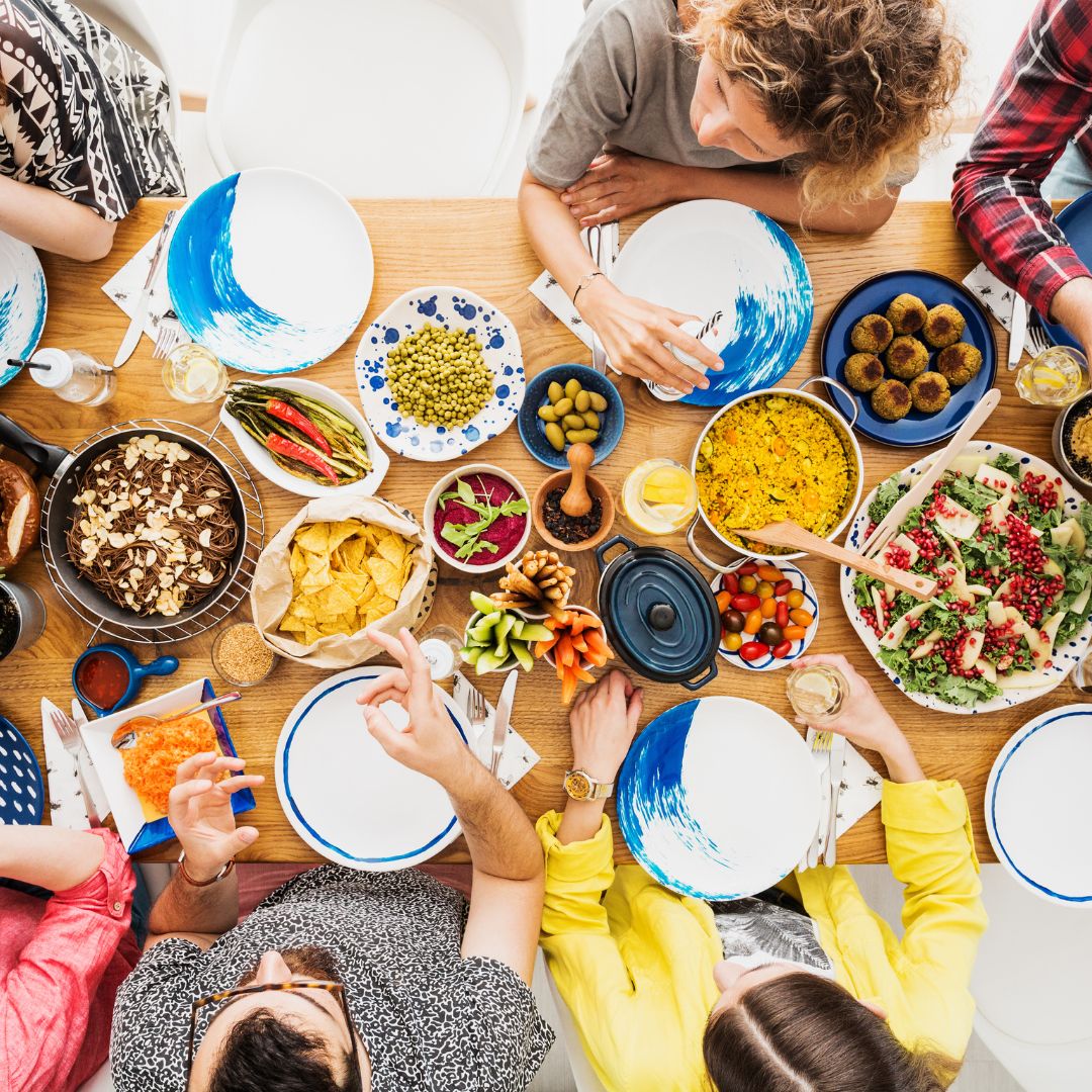 Aerial image of friends eating with various dishes on the dinner table