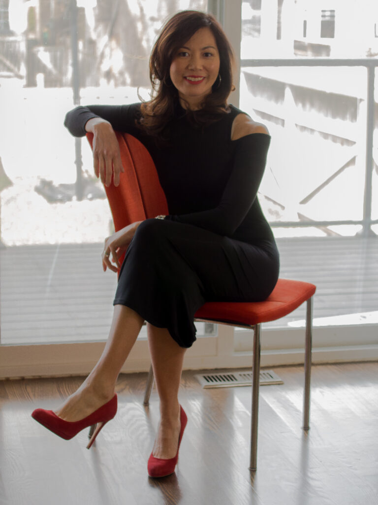 Sue Mah sitting on a red chair